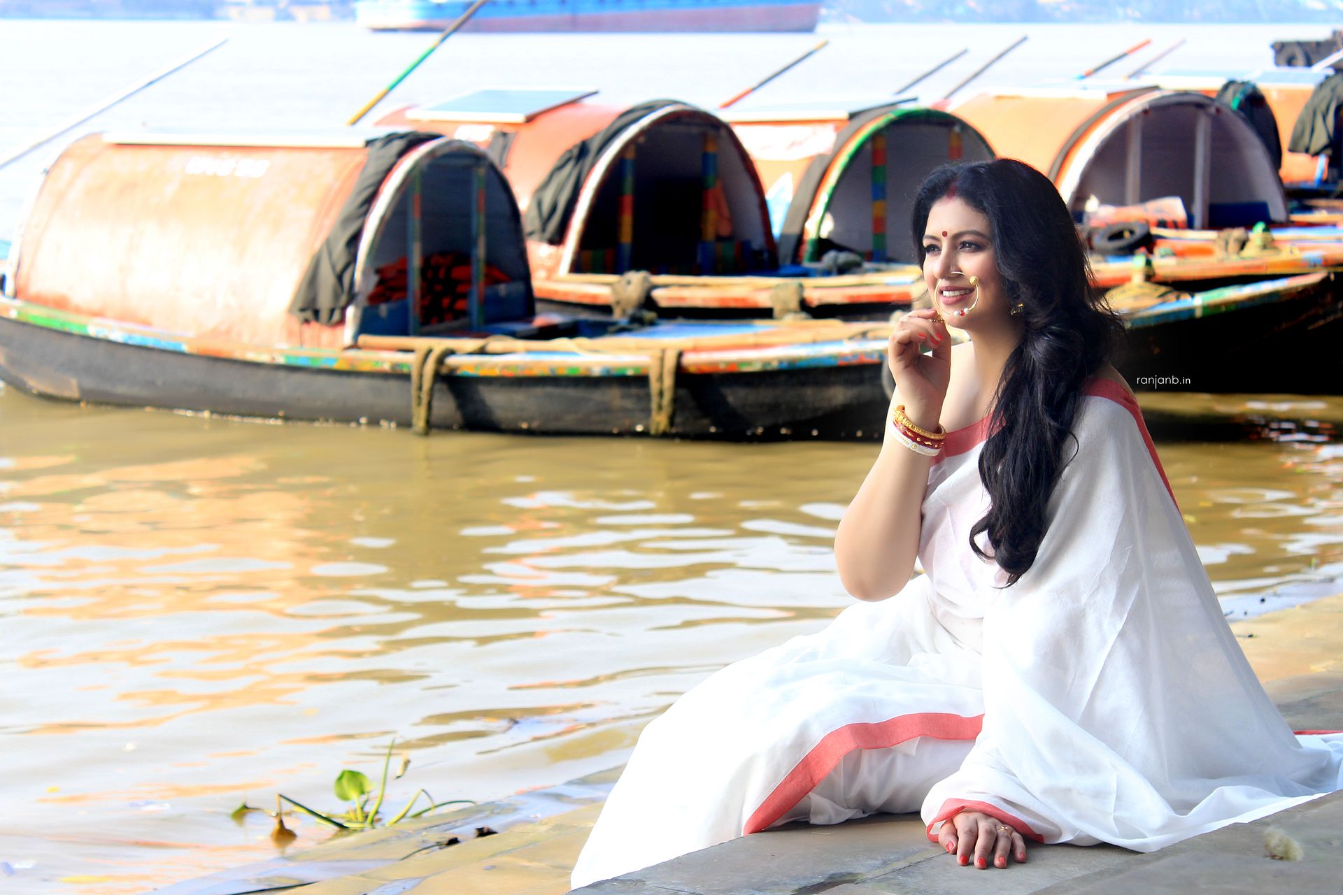 Portrait of Hasin Jahan wearing a red saree with gold detailing and traditional jewelry, captured by Ranjan Bhattacharya, showcasing her elegance and cultural heritage.