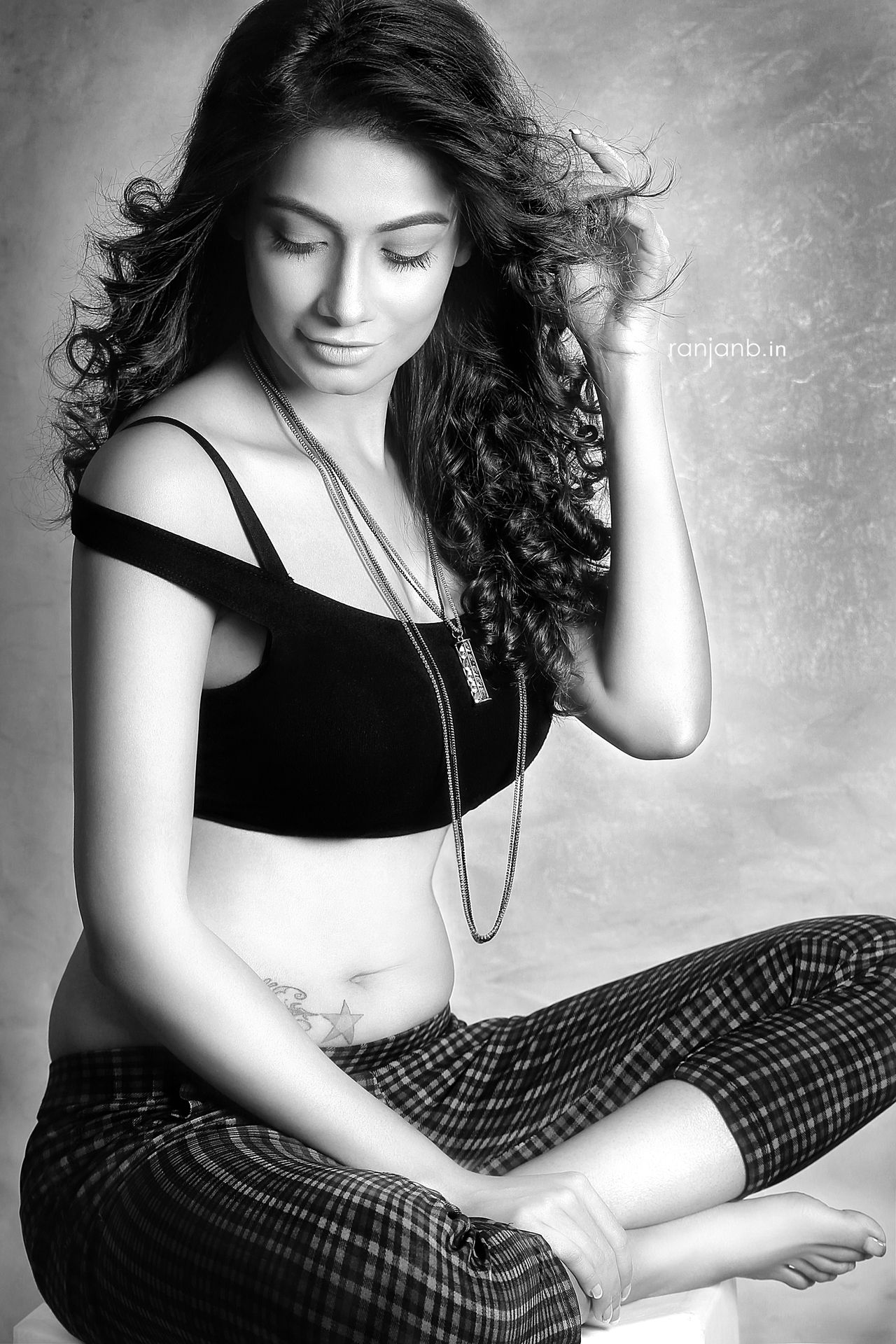 A stylish woman in a black top and plaid pants, photographed by Ranjan Bhattacharya, featuring Sumana Singh.