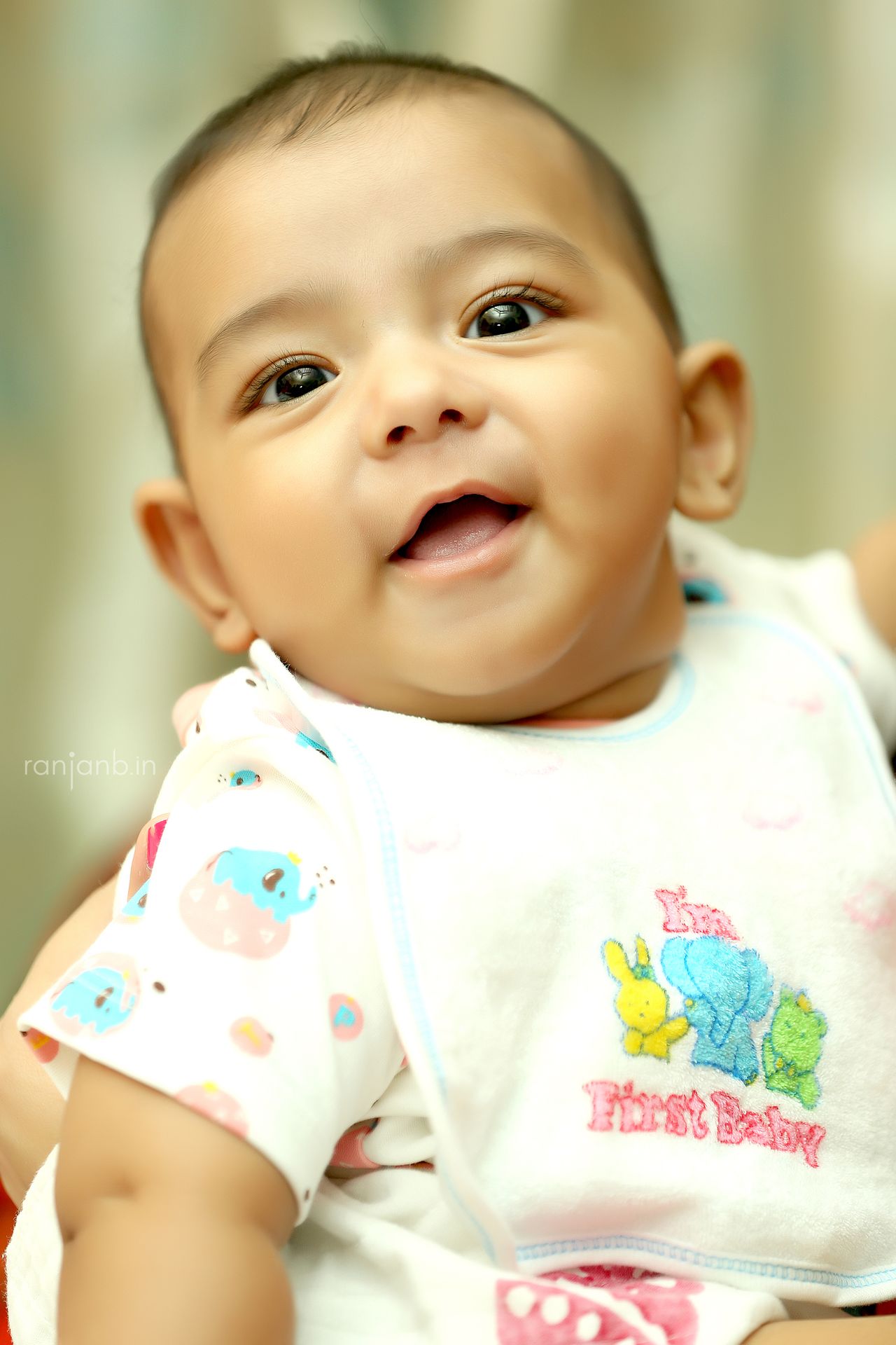 In a heartwarming portrait, baby Kiaan smiles brightly at his first rice ceremony, skillfully photographed by Ranjan Bhattacharya.