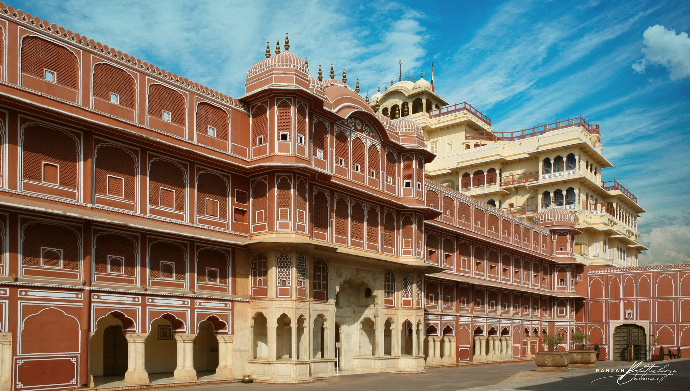 A large, ornate building with traditional Indian architecture, featuring multiple levels, arched windows, and intricate designs. Photo by Ranjan Bhattacharya.