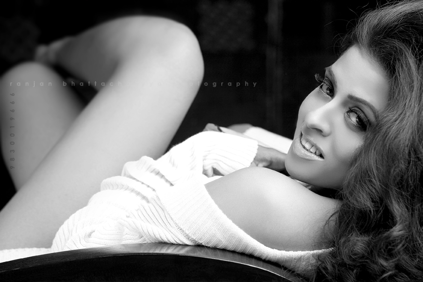 Portfolio image of a woman in a white sweater relaxing on a chair, captured by Ranjan Bhattacharya with makeup by Nanda Majumdar.