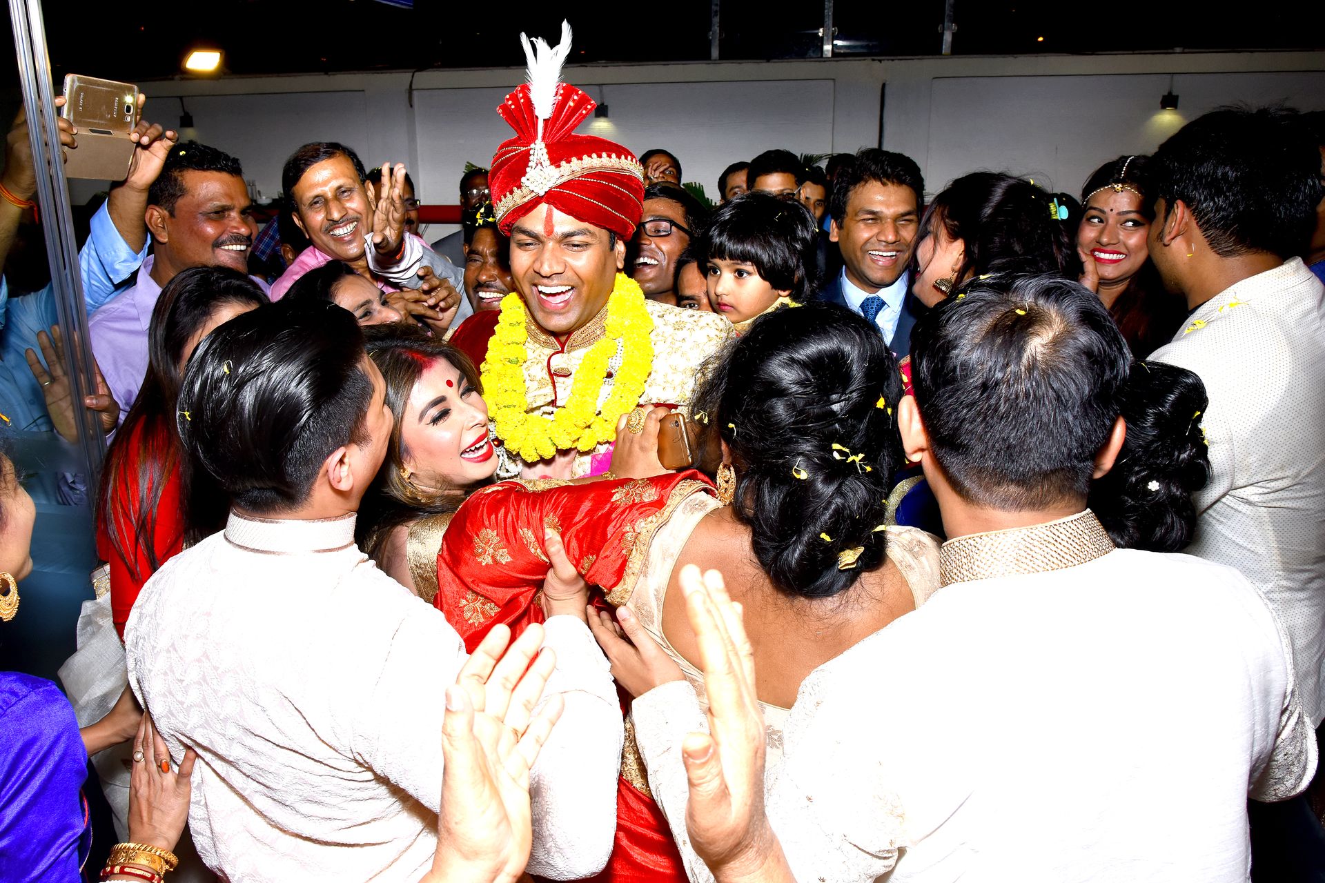 Candid shot of the groom sharing a laugh during their wedding reception.