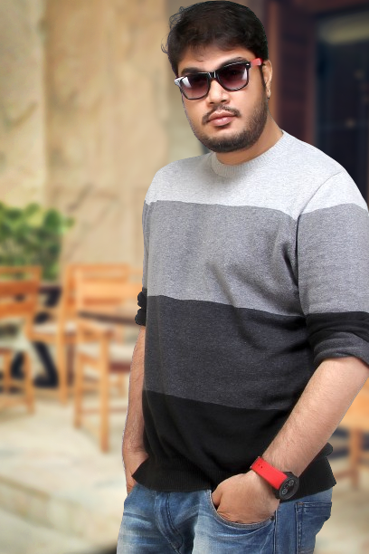 A professional studio portrait of photographer Ranjan Bhattacharya, showcasing a thoughtful expression with classic studio lighting.