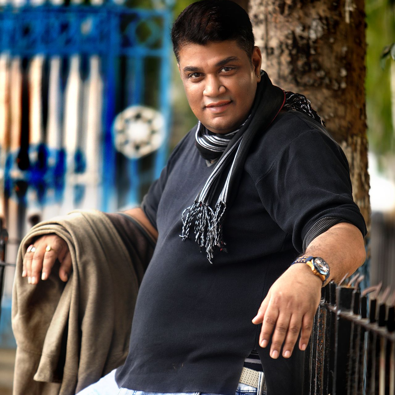 Ranjan Bhattacharya posing relaxed with a smile, embodying the essence of passion and excellence in photography.