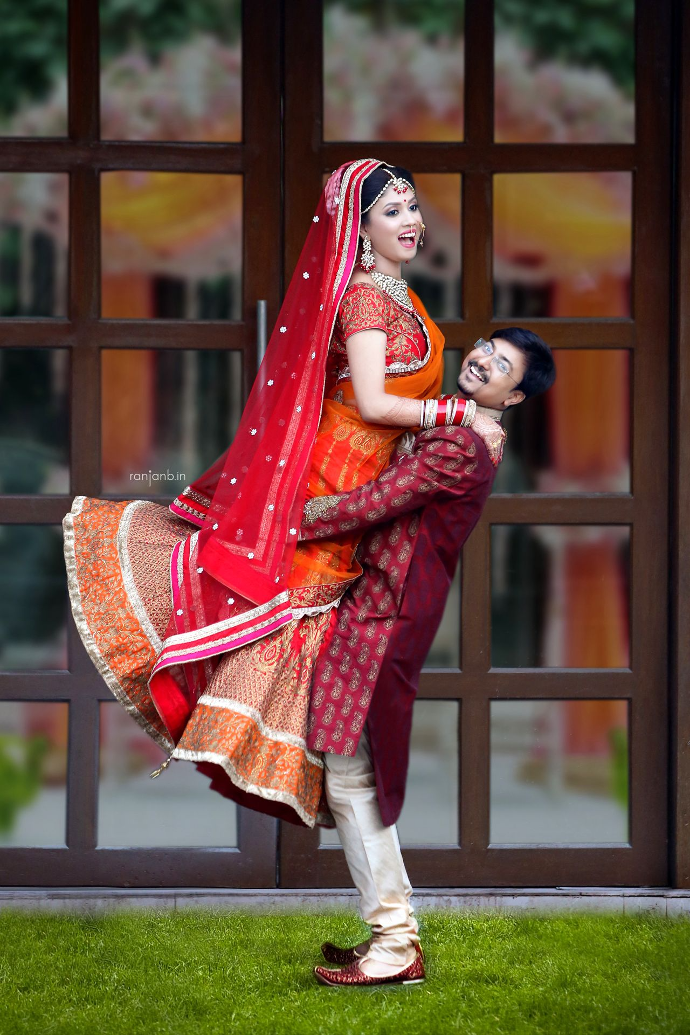 A joyful wedding moment where a guy lifts his fiancée, captured by photographer Ranjan Bhattacharya.